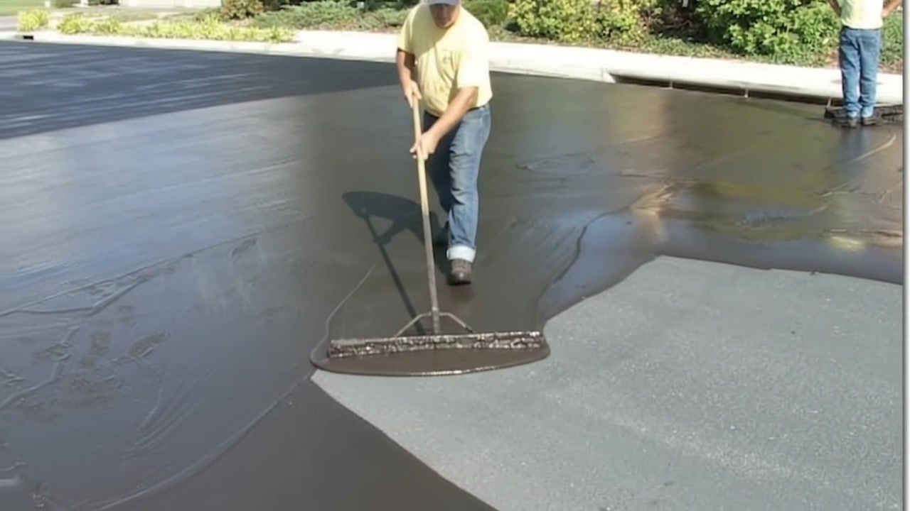 Worker Sealcoating Asphalt Driveway Application