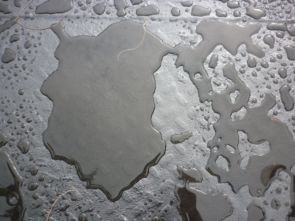 Water beading on sealed pavement under 150 cm pressure pipe column